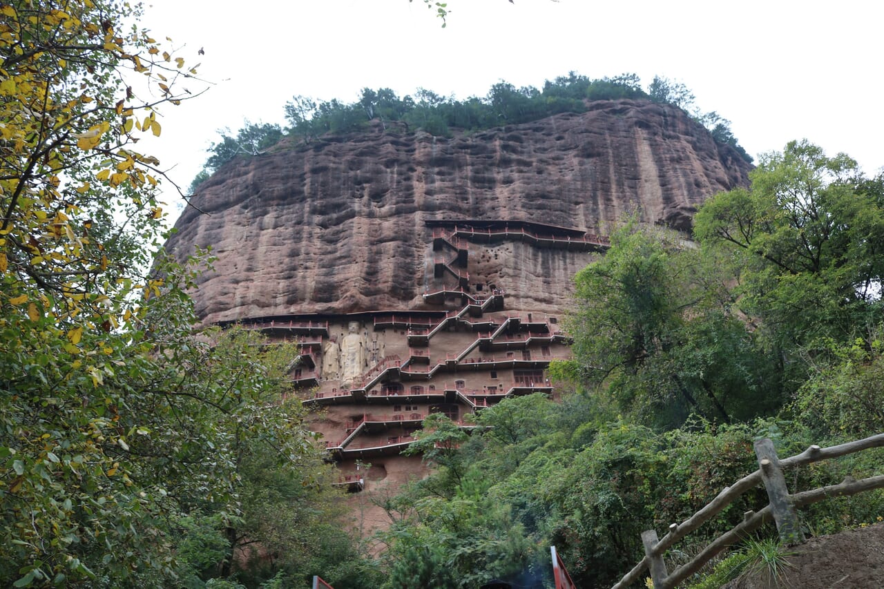 麦積山を登り始めると断崖に掘られたいくつもの石窟が見えてきました